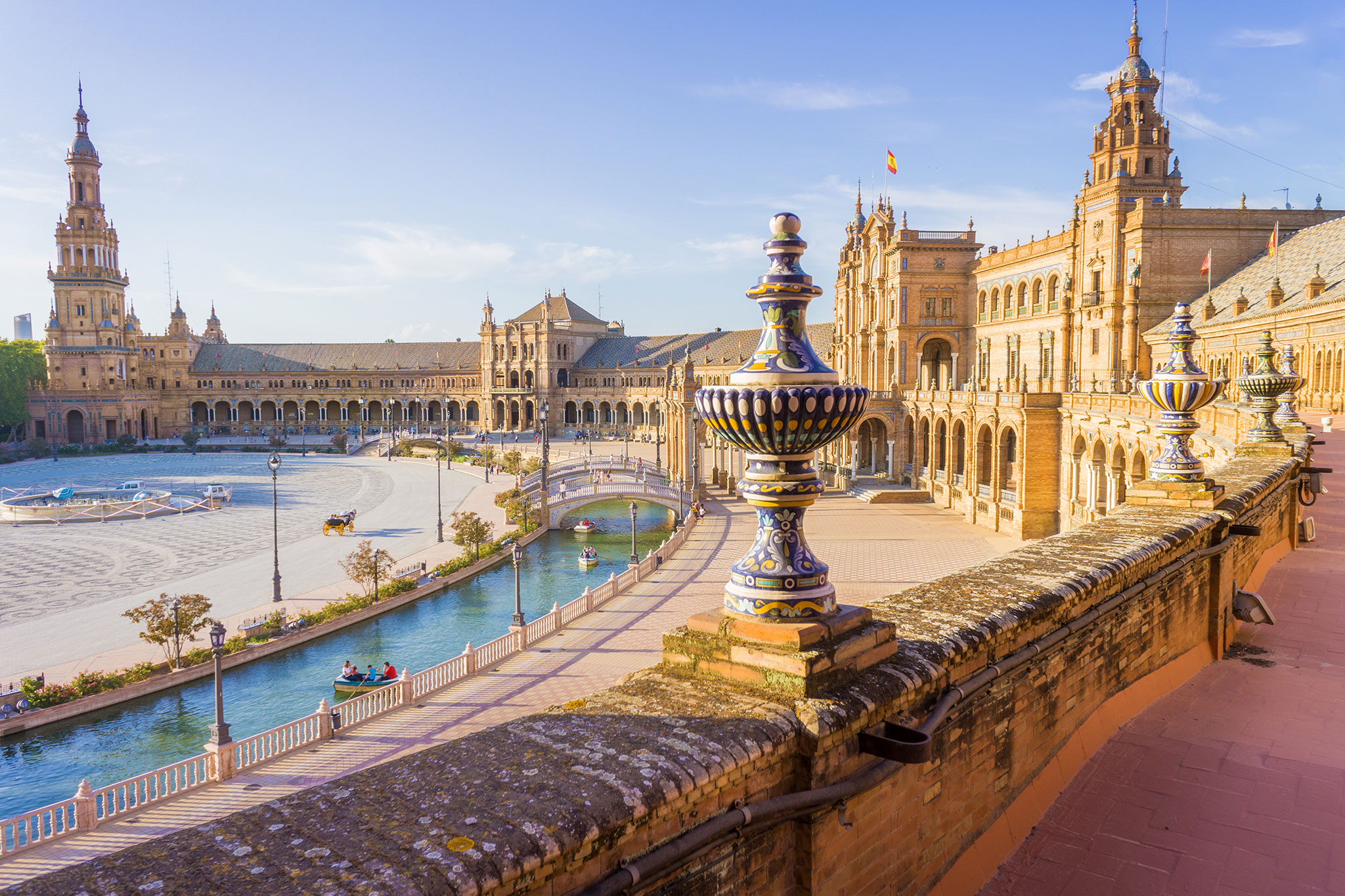 Scenic overlook of historic square with towers, tile work, and canal boats.
