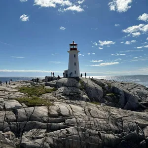 Lighthouse on a rocky surface with blue sky in the background