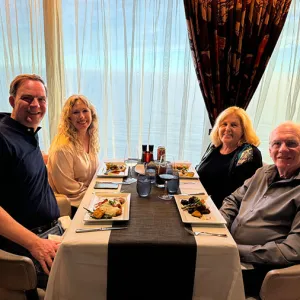 Smiling group of people sitting at an elegant dining table